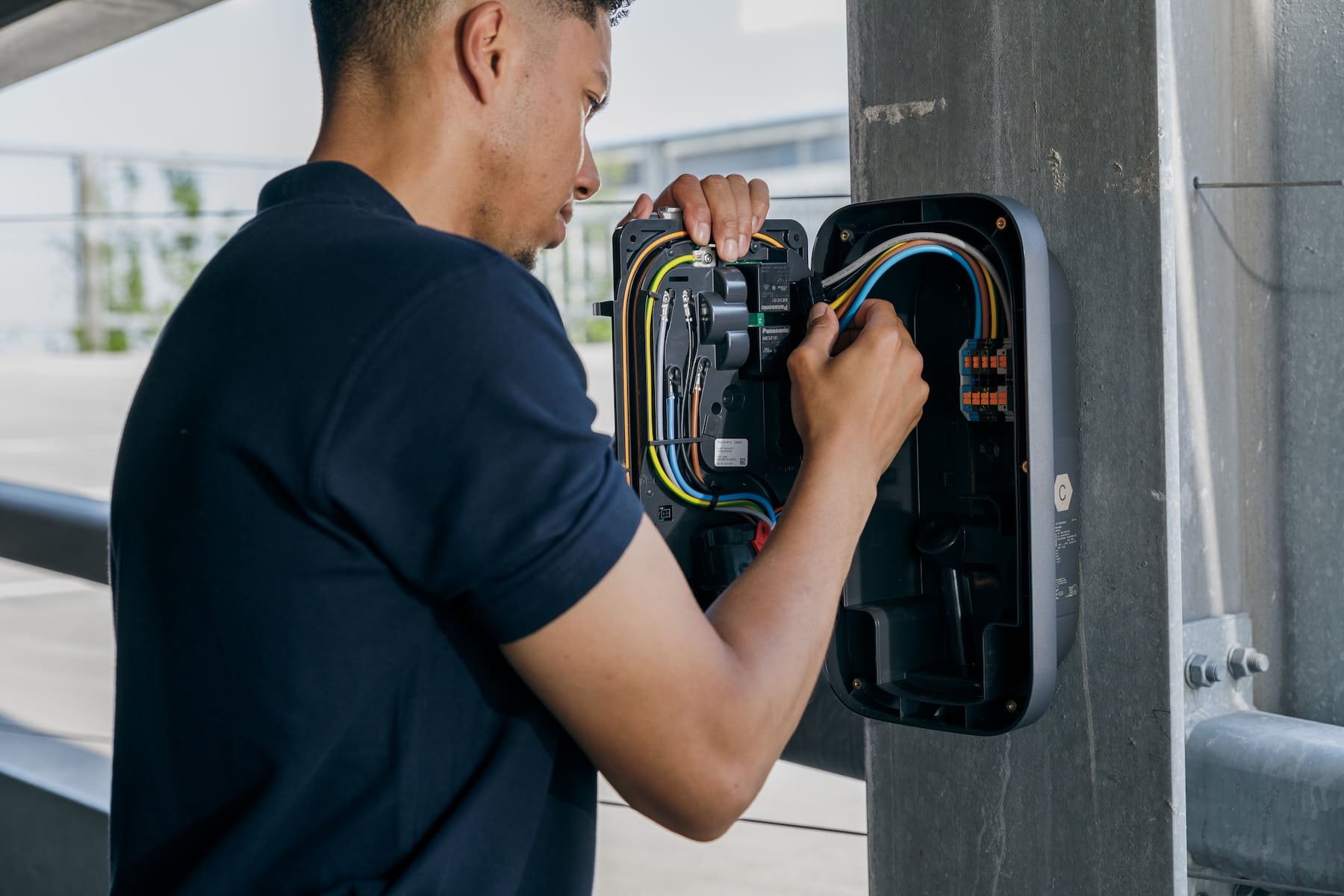 Installateur sluit de bedrading aan van een Peblar Business laadpaal